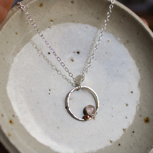 rose quartz cabochon on a silver halo necklace with copper ball detail